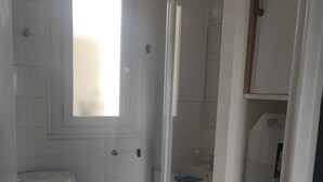 A compact bathroom with a toilet, a small sink, and a shower enclosure. - T4, Crossing, 3bed, quiet, Metro D'parking 7 /7.  Secure residence. (Vénissieux)
