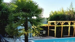 Una preparación para el desayuno con una mesa, alimentos para el desayuno y una piscina, además de asientos al aire libre.