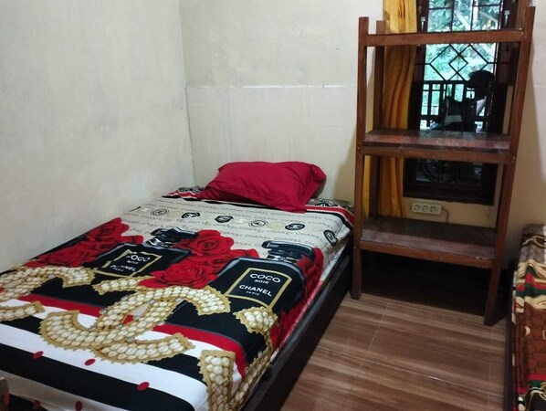 A small, single-bed room with a wooden ladder and a window with a view of greenery. - Villa Ndelik Ijen (Banyuwangi)