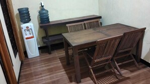 A small dining area with a wooden table and chairs, a bench, and two water dispensers. - Villa Ndelik Ijen (Banyuwangi)