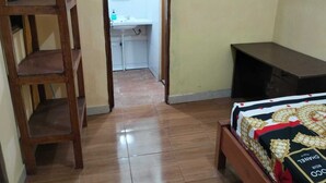 A bedroom with a wooden bed, a desk, and a chair. - Villa Ndelik Ijen (Banyuwangi)