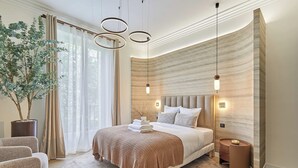 Una camera da letto moderna con un letto grande, una pianta in vaso e vista sull'esterno.