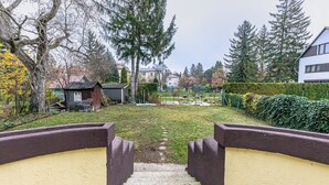 A residential area with a pathway leading to a house, surrounded by trees and a well-maintained lawn.