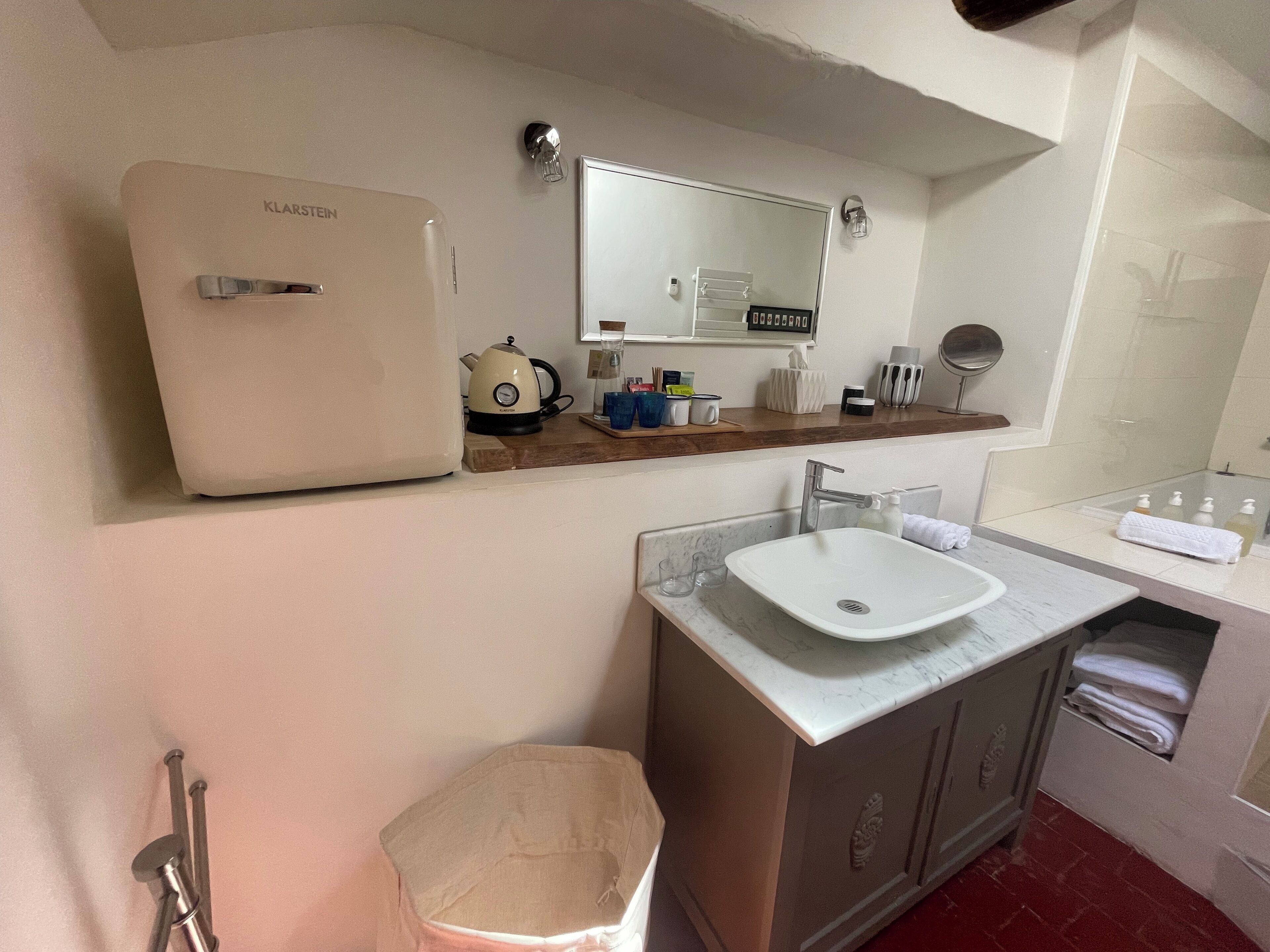 A compact bathroom with a white sink, a mirror, and a small cabinet.