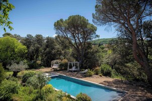 Una piscina al aire libre de temporada, sombrillas