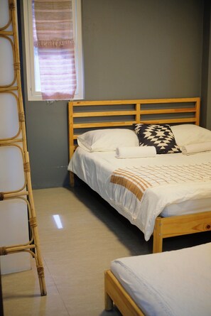 A single bed with a wooden frame, a white mattress, and a patterned pillow. - 2BR laid back apartment, near beach (San Fernando City)