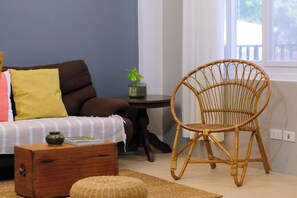 A room with a sofa, a wicker chair, a small table with a plant, and a wooden chest of drawers. - 2BR laid back apartment, near beach (San Fernando City)