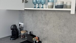 Eine moderne Küche mit einer schwarzen Spüle, einer Kaffeemaschine und einem Zuckerdose.