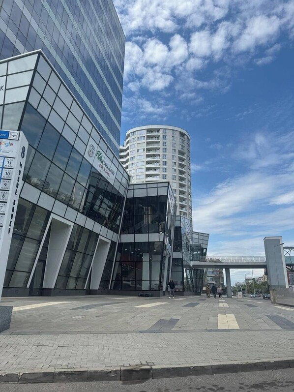 A modern building with a glass facade and a curved structure.
