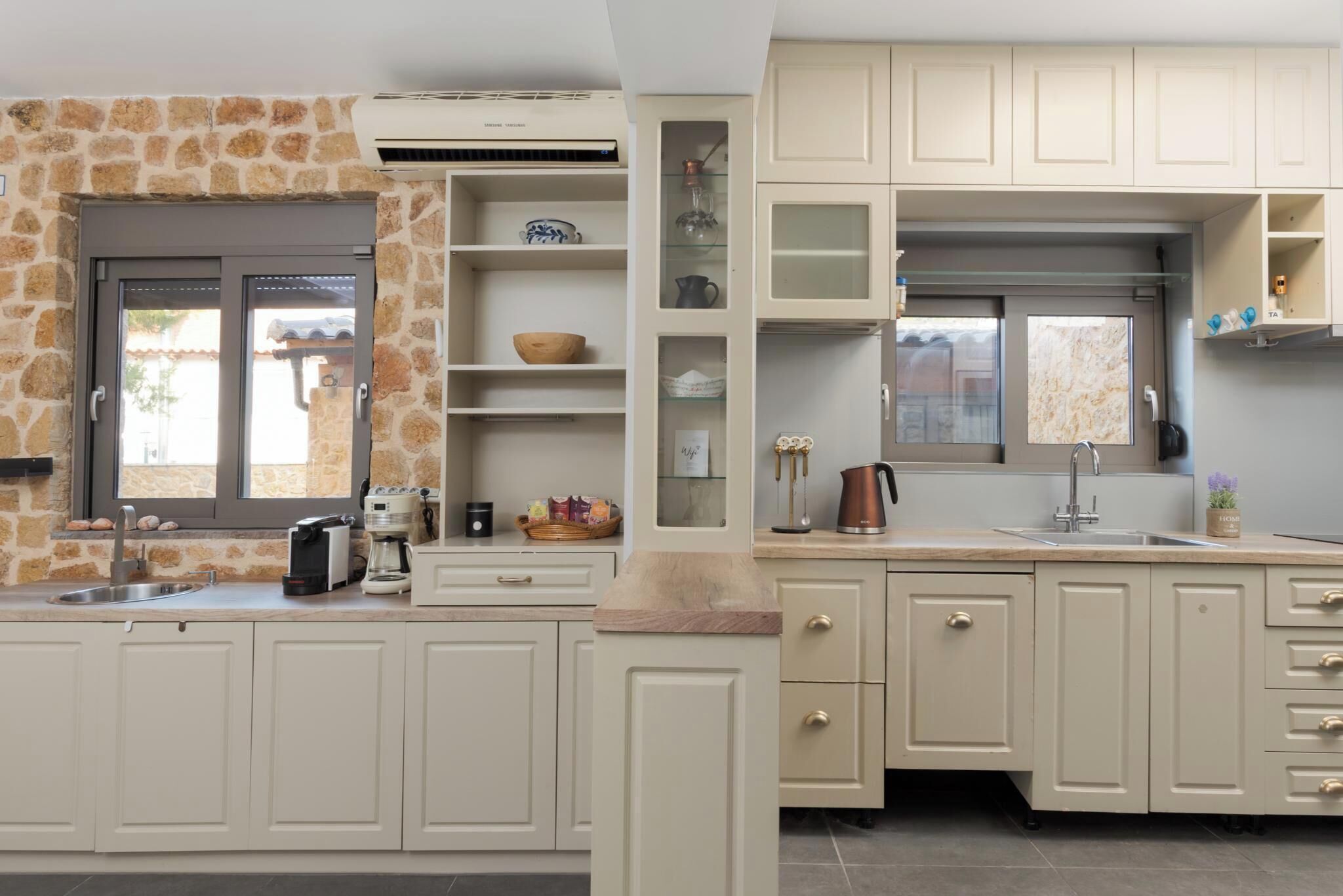 A kitchen with stone walls, a built-in oven, and a window with a view.