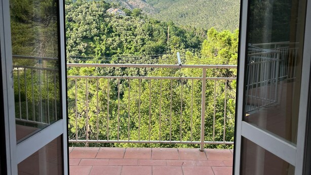 Ein Balkon mit Blick auf eine gebirgige Landschaft.