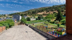 Un parque infantil con una estructura para escalar y una cancha de baloncesto.