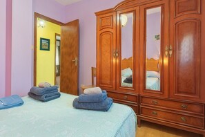 Un dormitorio con cama, armario y puerta que da a otra habitación.