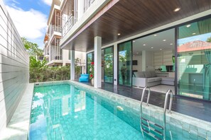 A modern residential building with a swimming pool, large glass windows, and a covered outdoor area. - Private Pool Villa UTK3 near Kata Beach (Karon)