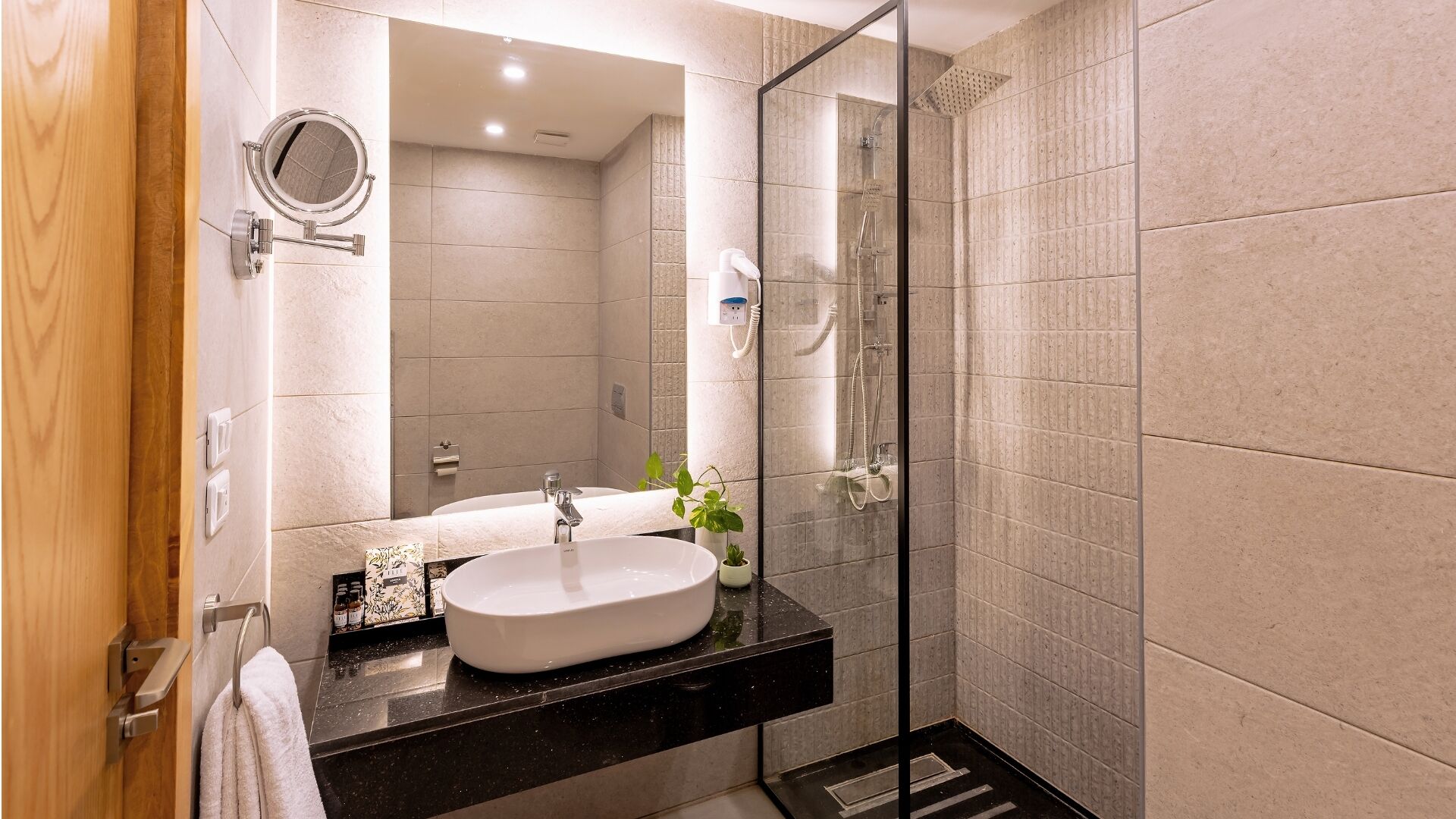 A modern bathroom with a freestanding bathtub, a glass shower enclosure, and a large mirror.