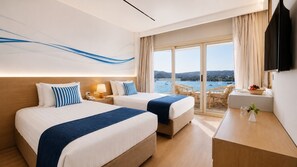A hotel room with two beds, a desk, a TV, and a balcony with a view of the sea. - Obelisk Nile Towers (Aswan)