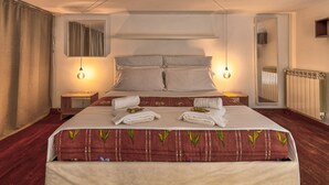 A hotel room with a large bed, two bedside tables, a mirror, and a radiator. - Casa Il Maestro by Rentbeat (Civitavecchia)