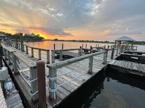 A wooden pier extending into calm water with a gazebo at the end.