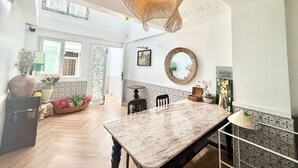 A spacious dining area with a large table, decorative ceiling light, and a view of the outdoors. - Cherry Blossom Boutique Hotel (Ho Chi Minh City)