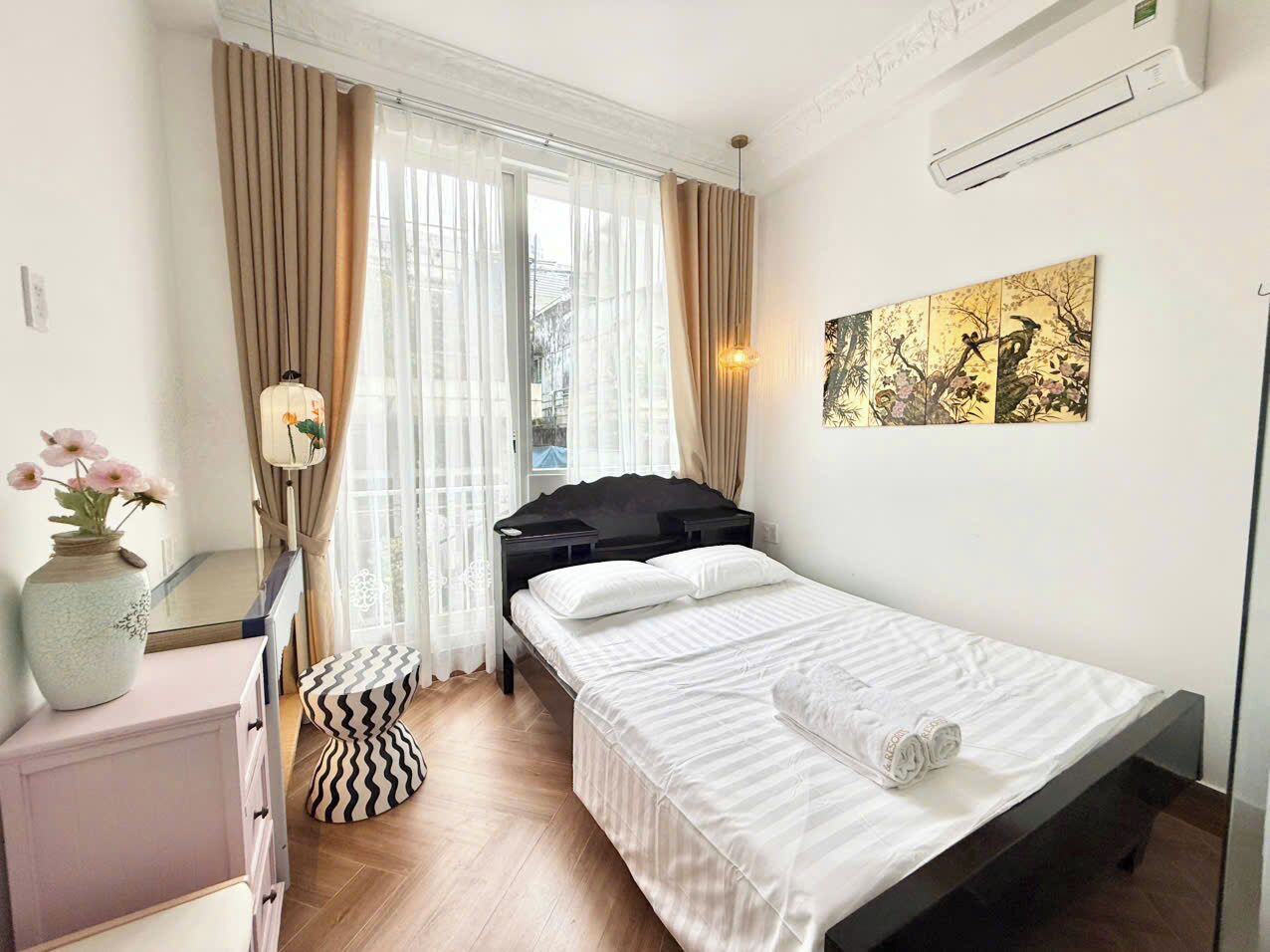 Une chambre à coucher bien rangée, avec un lit, une table de chevet et un miroir.
