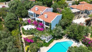 A two-story house with a swimming pool, surrounded by lush greenery and flowering plants. - Villa Lycia with Sea Platform (Kas)