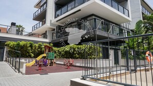 A modern building with a children's play area, including slides and swings, and a clear sky. - CostaBlancaDreams - Apartment Casobel in Javea (Javea / Xàbia)