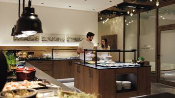 A buffet setup with a variety of food items and a counter where staff are serving.