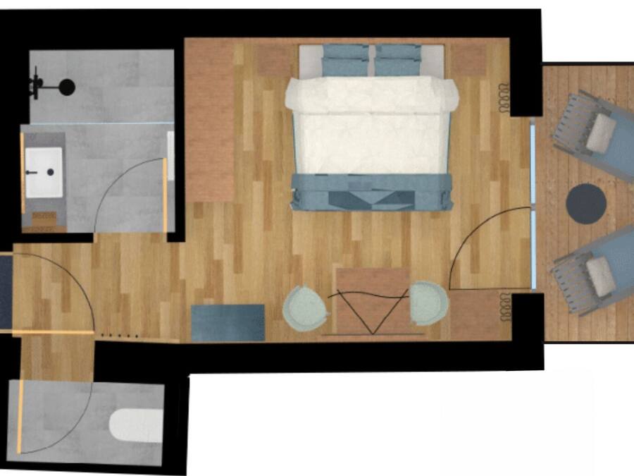 Distribución de una habitación de hotel con una cama, dos zonas de estar, una mesita, un lavamanos y un inodoro.