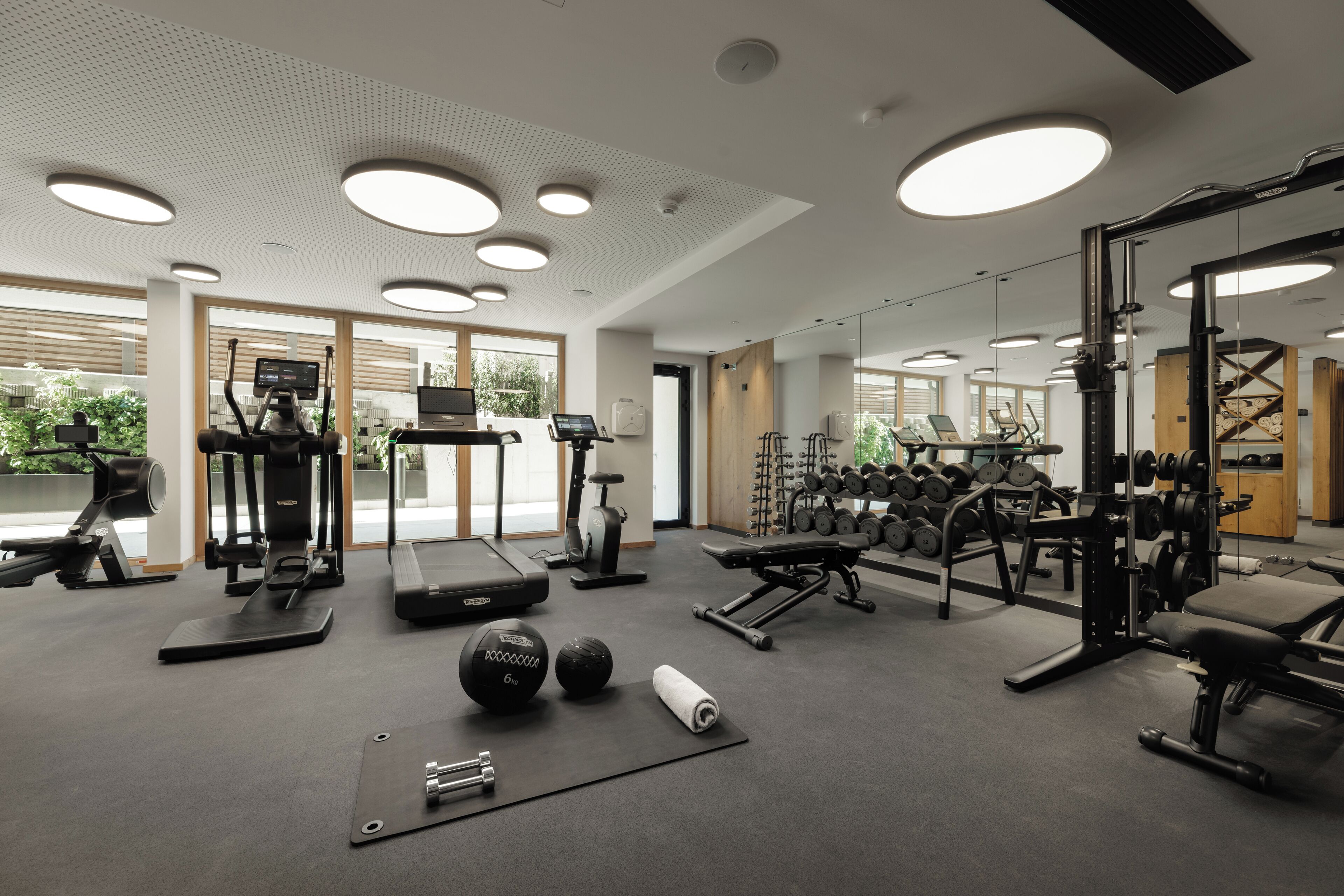 A modern gym with treadmills, weight machines, and free weights.