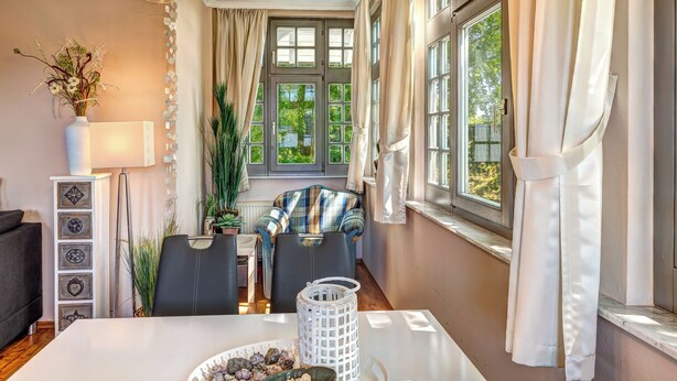 Un comedor con una mesa, sillas y vistas al exterior con vegetación.