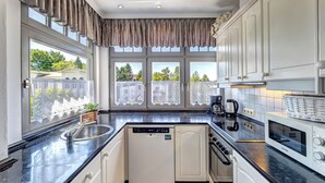 Una cocina moderna con lavavajillas, horno y microondas.