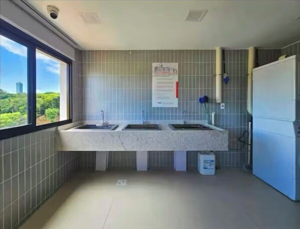 Una cocina moderna con dos fregaderos, un refrigerador y una ventana con vistas a la ciudad.