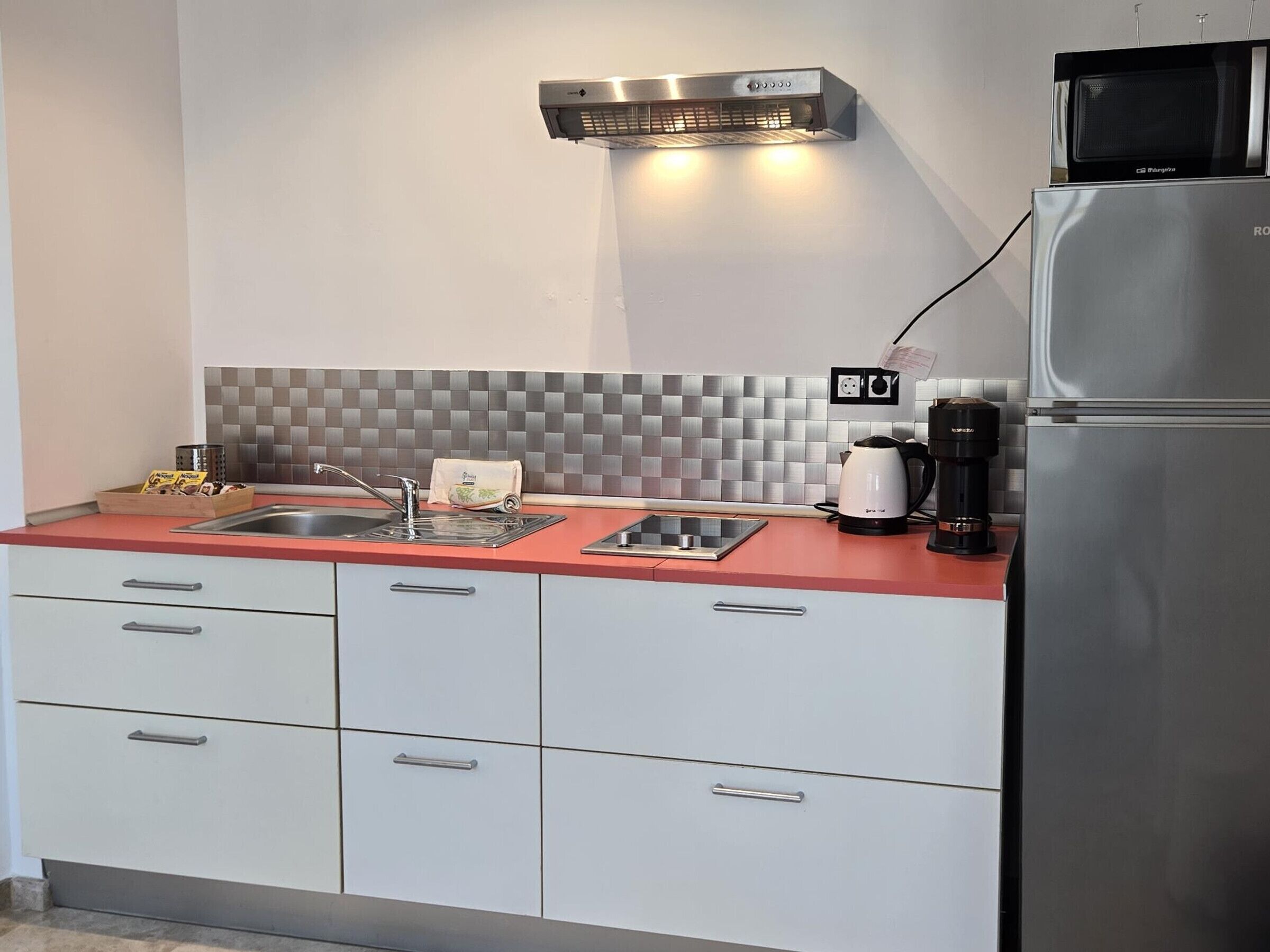 Een koffiezetapparaat/waterkoker, een koelkast, een magnetron