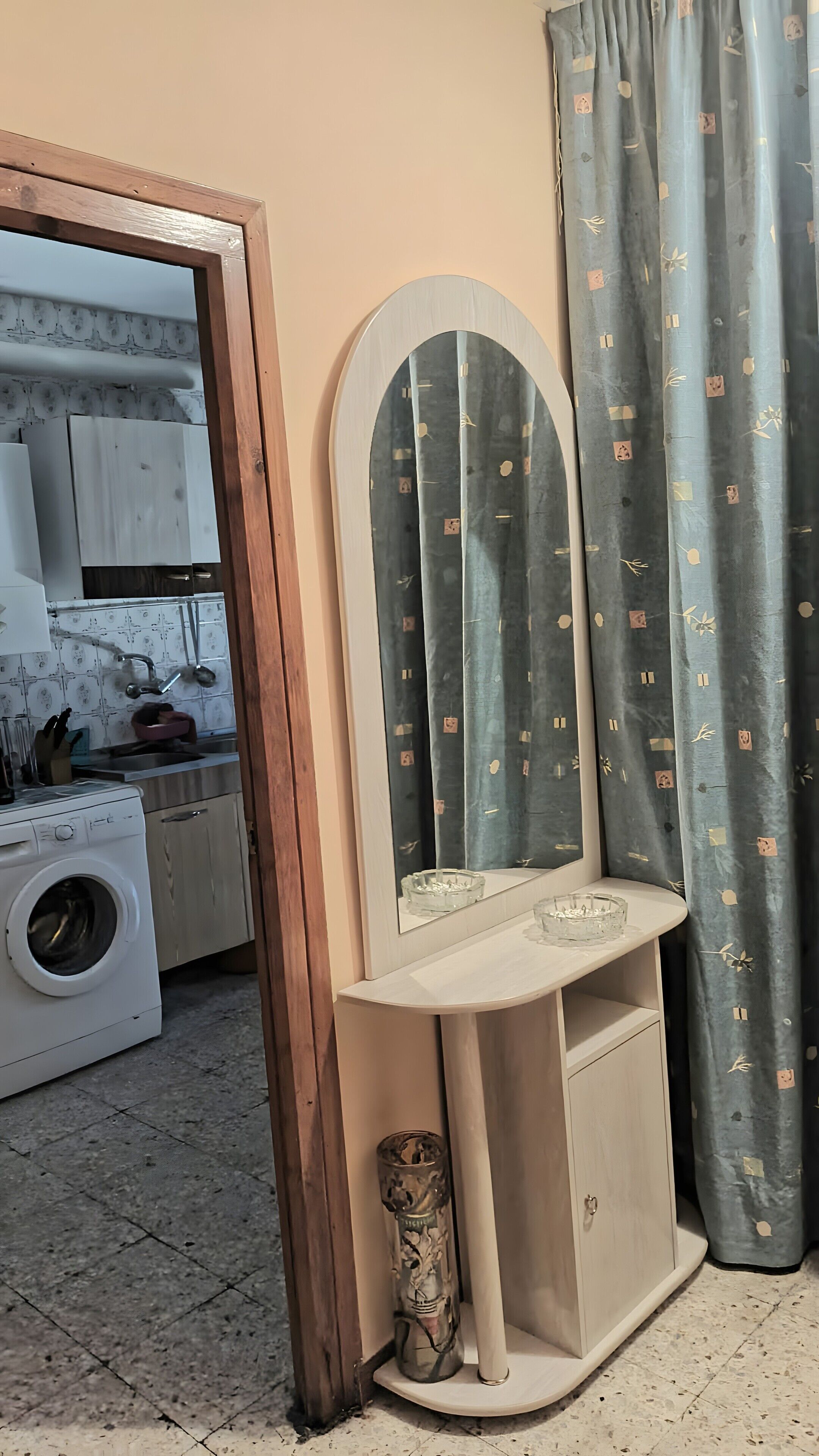 Un mobile bagno con specchio, lavabo e un vaso decorativo.