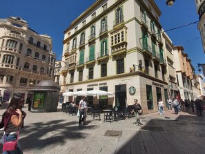 A building with a Starbucks coffee shop on the ground floor, featuring outdoor seating and a manhole cover in the center. - Design Suites in Malaga Center, max 4 guests (Málaga)