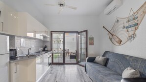A modern kitchen with a dining area, a sofa, and a hammock.