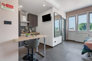 Een moderne keuken met een eethoek, een televisie en een groot raam met uitzicht.