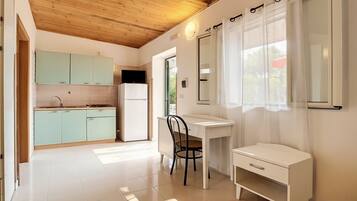 Een koelkast, een kookplaat, kookgerei, borden en bestek