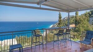 A balcony with a view of the sea, a table, and two chairs. - Country House 'Sea View 2' with Sea View, Wi-Fi and Air Conditioning (Lefkada)