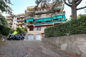A multi-story residential building with balconies, a paved driveway, and parked motorcycles. - ‘Terrazzo Del Gelsomino’ Apartment with Private Terrace (Rapallo)