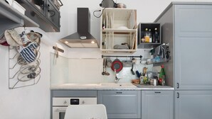 A kitchen with a white countertop, a stove, a sink, and a dish rack. - ‘Terrazzo Del Gelsomino’ Apartment with Private Terrace (Rapallo)