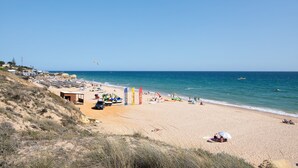A beach with a sandy shore, a small building, and a clear blue sky. - Apartment 'Salgados Beach House' with Shared Pool, Wi-Fi and Air Conditioning (Albufeira)
