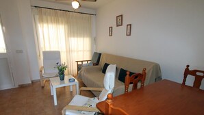 Una habitación con cama, sofá, mesa de comedor y una silla.
