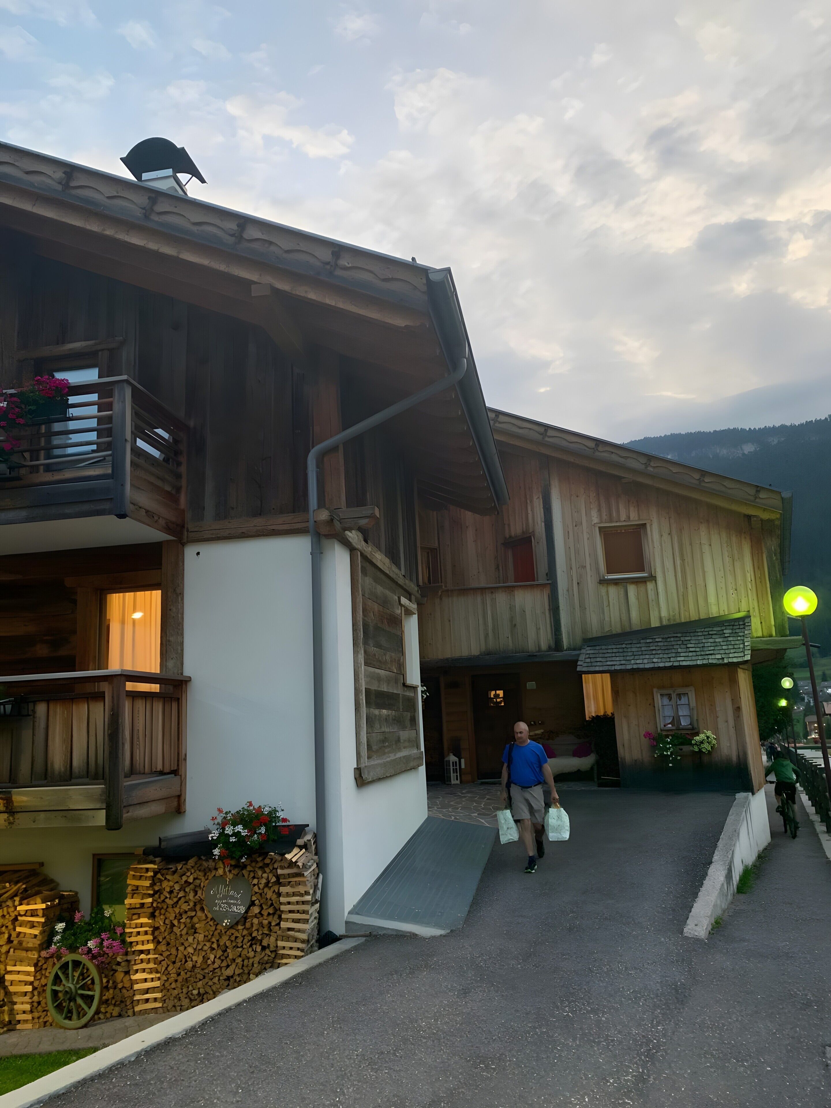 A wooden building with a balcony and a staircase leading to the entrance.