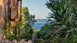 Un sendero en un jardín que lleva a un edificio con vistas al mar y a las montañas.