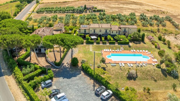 Vue aérienne d’une propriété comprenant une piscine, plusieurs villas et un environnement verdoyant.