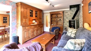 Una sala de estar acogedora con un aparador de madera, un sofá, una mesa de centro y una chimenea.