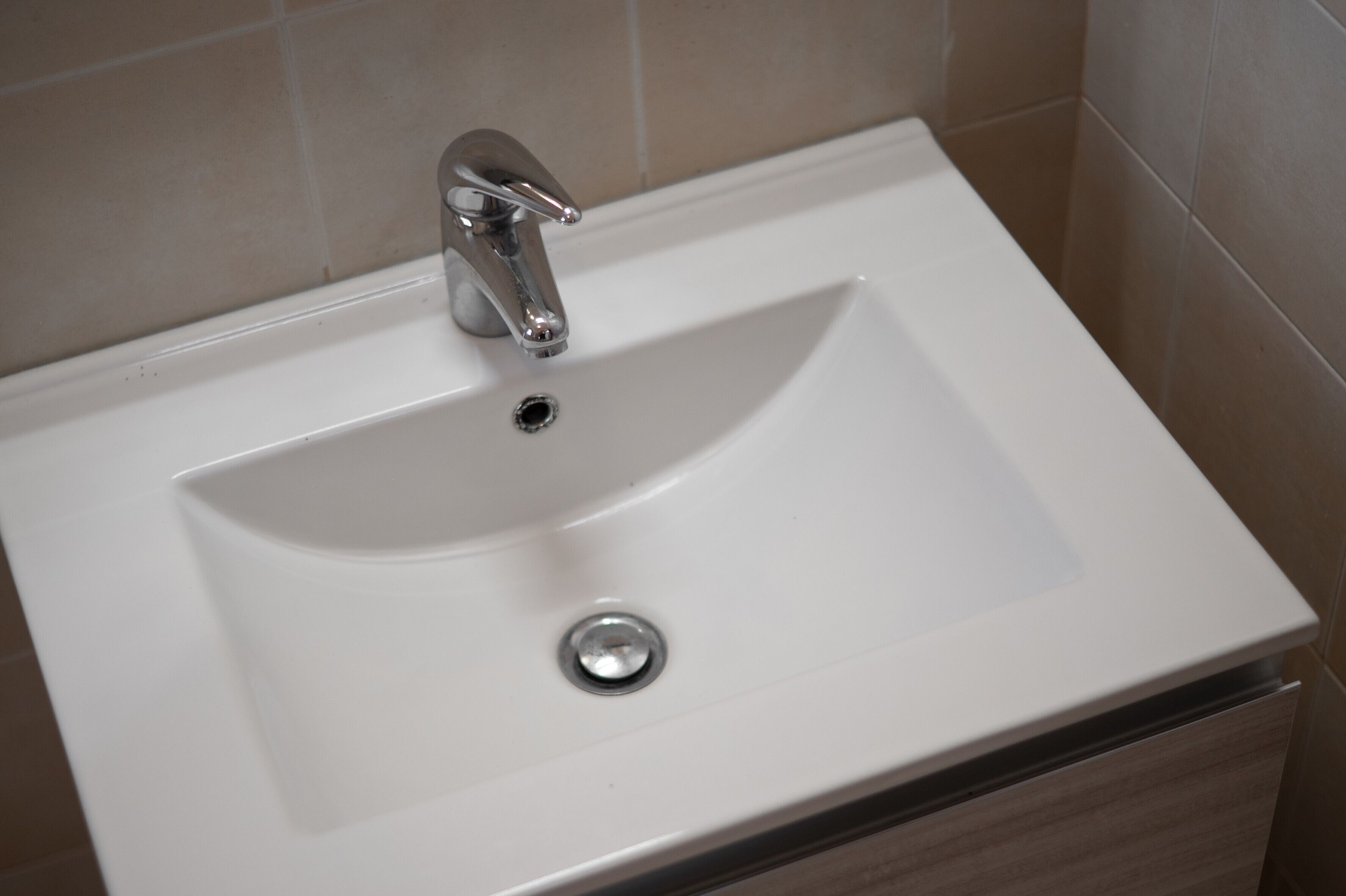 A bathroom sink with a chrome faucet and a drain.