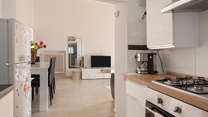 Eine moderne Küche mit Herd, Kühlschrank und Essbereich.