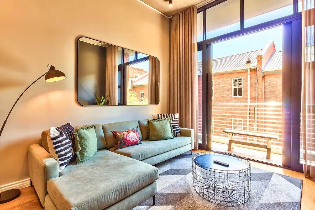 A modern living room with a sofa, a coffee table, and a floor lamp.